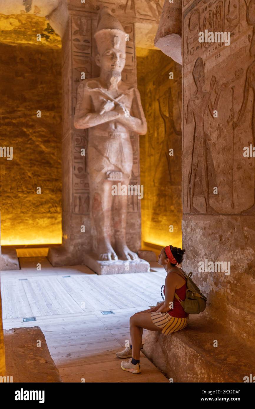 Una donna seduta all'interno di un tempio egiziano Foto Stock
