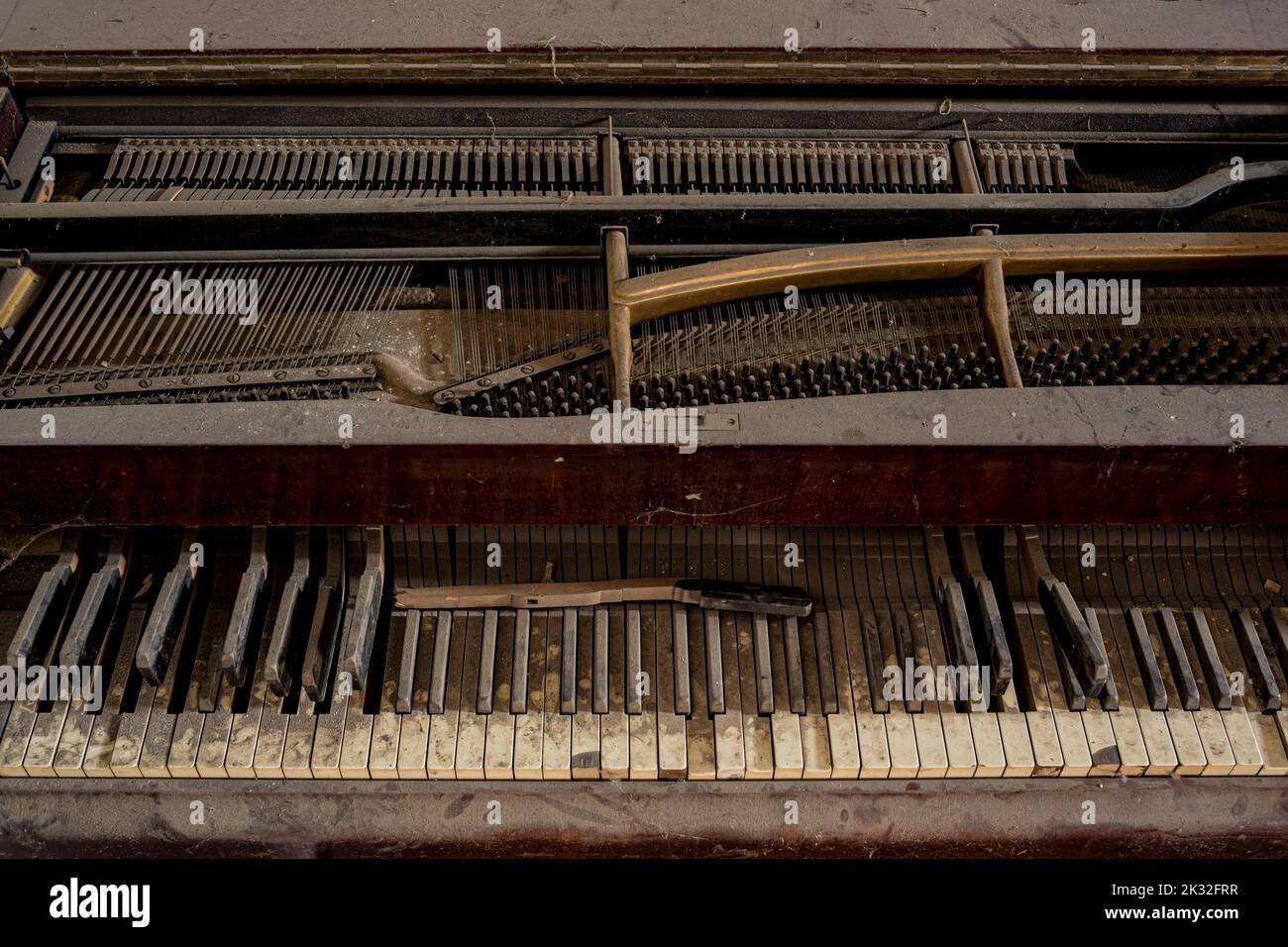 Primo piano con sfondo urbex di tastiera acustica classica a pianoforte a coda con tasti bianchi e neri dalle tonalità seppia pieni di polvere. Schermo intero creativo Foto Stock