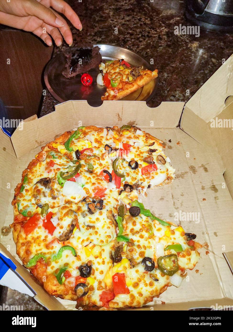 Pizza Party. Mescolare la pizza di verdure e funghi con una fetta di verdure prelevate. Dehradun India. Foto Stock