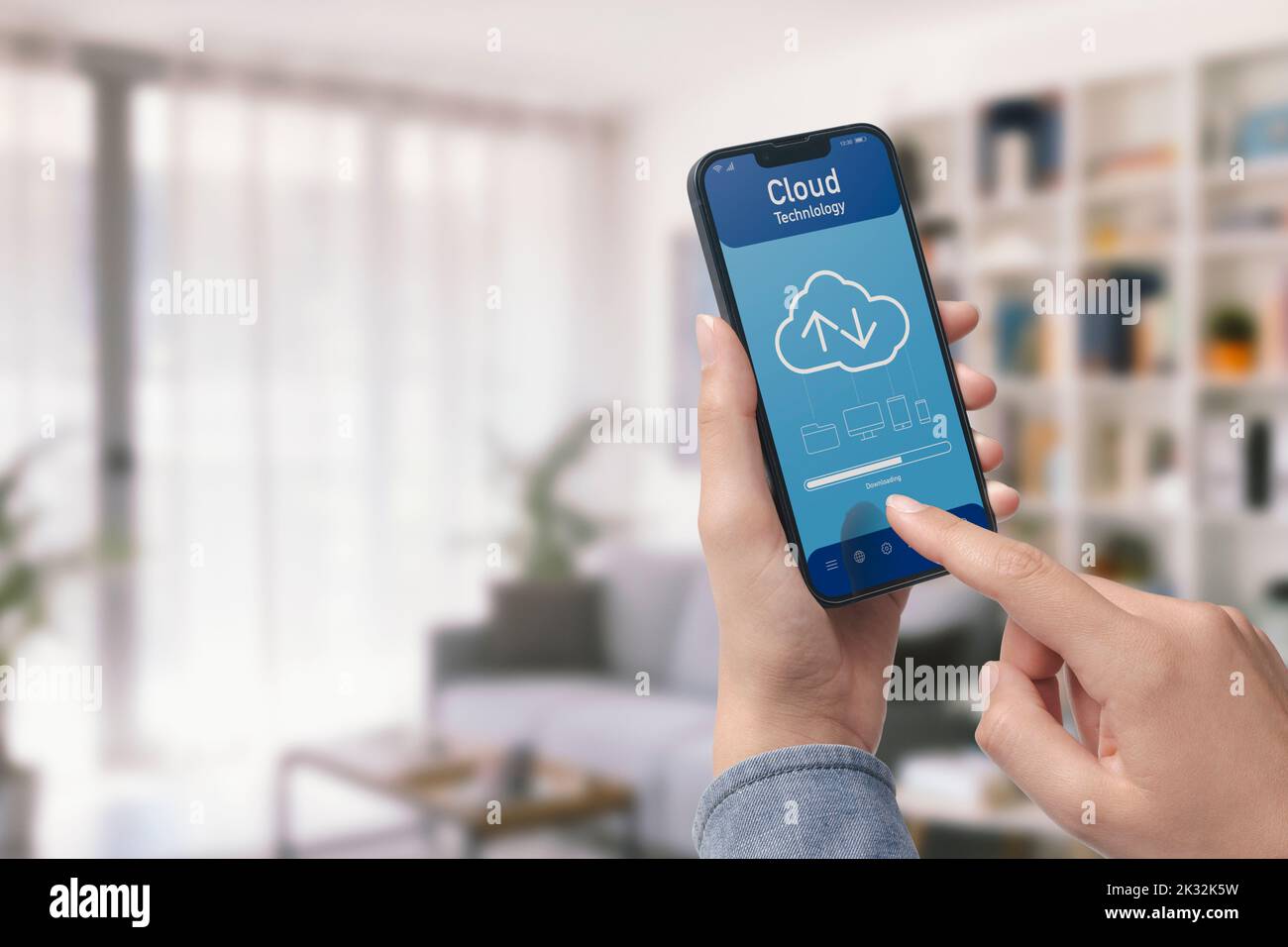 Tenendo uno smartphone e un'applicazione basata su cloud, l'utente sta scaricando i dati sul dispositivo, POV shot Foto Stock