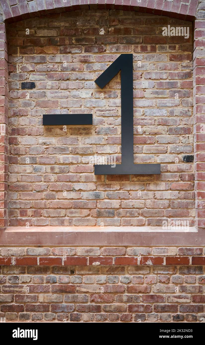 Indicatore numerico sulla parete di mattoni sabbiati che mostra l'area del seminterrato Foto Stock