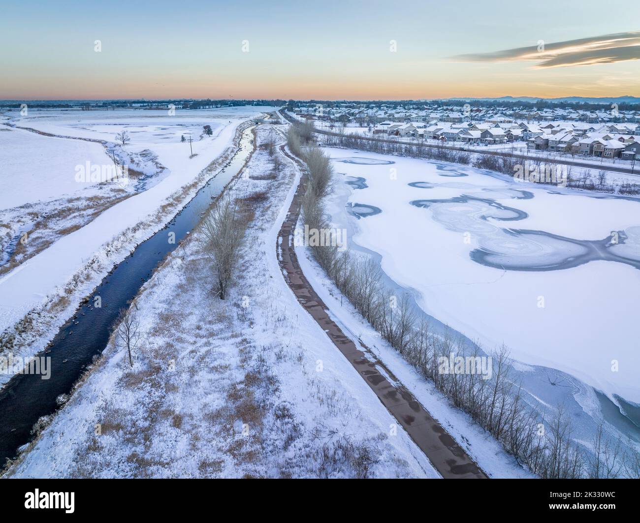 Canale di irrigazione, pista ciclabile e laghetto ghiacciato, scenario invernale dopo il tramonto, vista aerea della zona di Fort Collins nel Colorado settentrionale Foto Stock