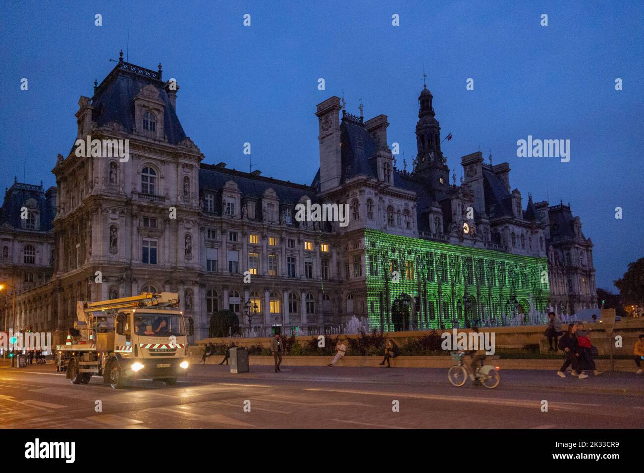 Il municipio di Parigi e Rue de Rivoli, con un camion, all'alba, con persone a piedi e uno spettacolo laser è proiettato sulla facciata del municipio Foto Stock