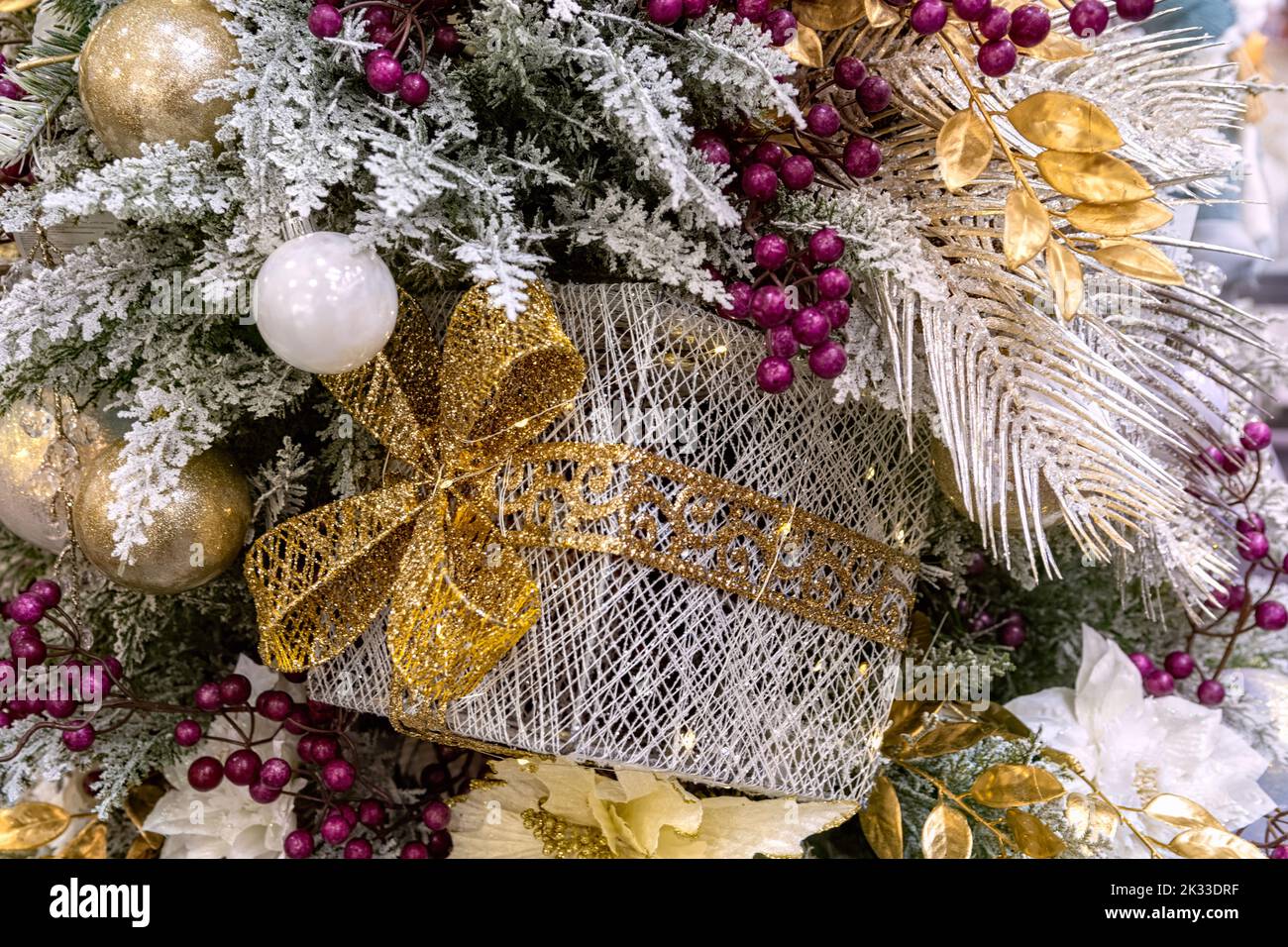 La scatola luminosa del regalo è appesa sull'albero di Natale. Contesto di Capodanno. Messa a fuoco selettiva. Foto Stock