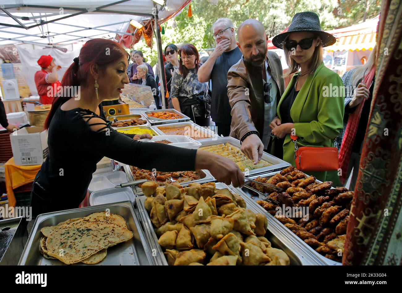 Bucarest, Romania. 24th Set, 2022. Una donna vende cibo indiano durante il 9th Asia Fest nel Parco Nazionale di Bucarest, capitale della Romania, 24 settembre 2022. Il festival di tre giorni comprende una serie di attività come mostre di prodotti e vendite da vari paesi, esperienze gastronomiche, spettacoli d'arte, mostre culturali, festival cinematografici, e laboratori artigianali. Credit: Cristian Cristel/Xinhua/Alamy Live News Foto Stock