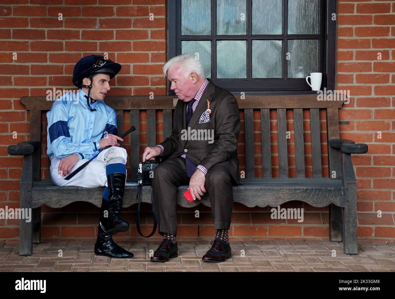 Il jockey William Buick chiacchiera con un racegoer durante il giorno di Juddmonte del Cambridgeshire Meeting all'ippodromo di Newmarket. Data immagine: Sabato 24 settembre 2022. Foto Stock