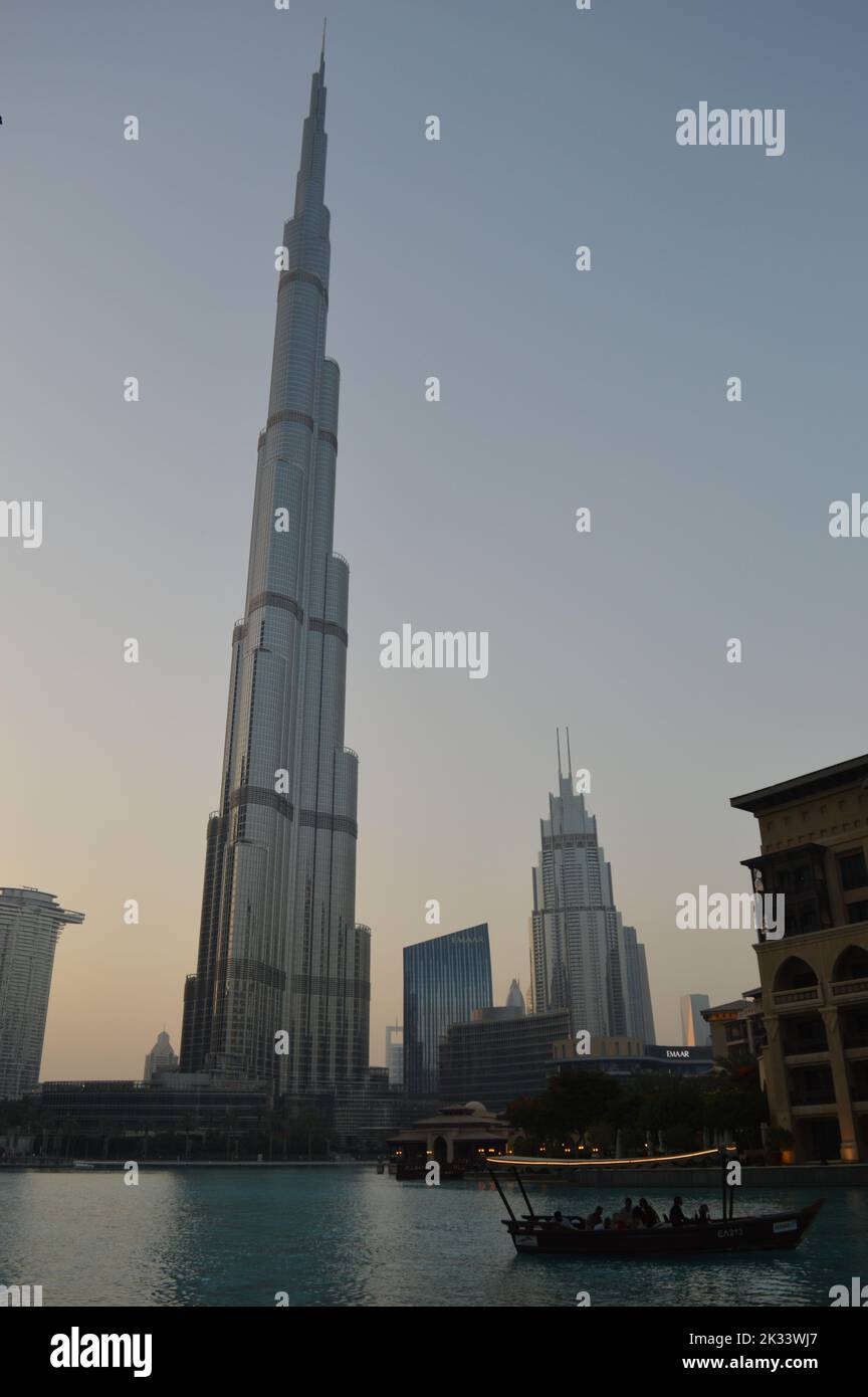 Dubai, Emirati Arabi Uniti. 31 maggio 2022: La torre più alta del mondo, Burj Khalifa durante il tramonto, mentre un'Abra passa sull'acqua della fontana. Foto Stock