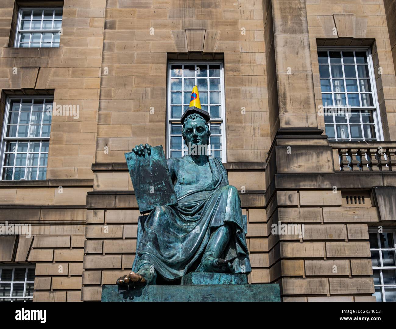Statua in bronzo di David Hume con il piede strofinato e il cono stradale sulla sua testa, Royal Mile, Edimburgo, Scozia, Regno Unito Foto Stock