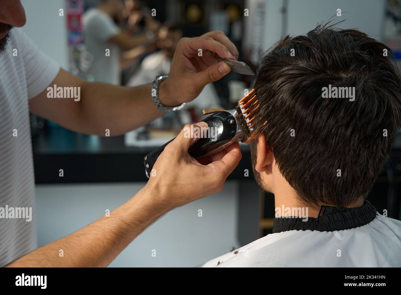 Giovane uomo che ottiene una rifinitura dei capelli al barbershop moderno Foto Stock