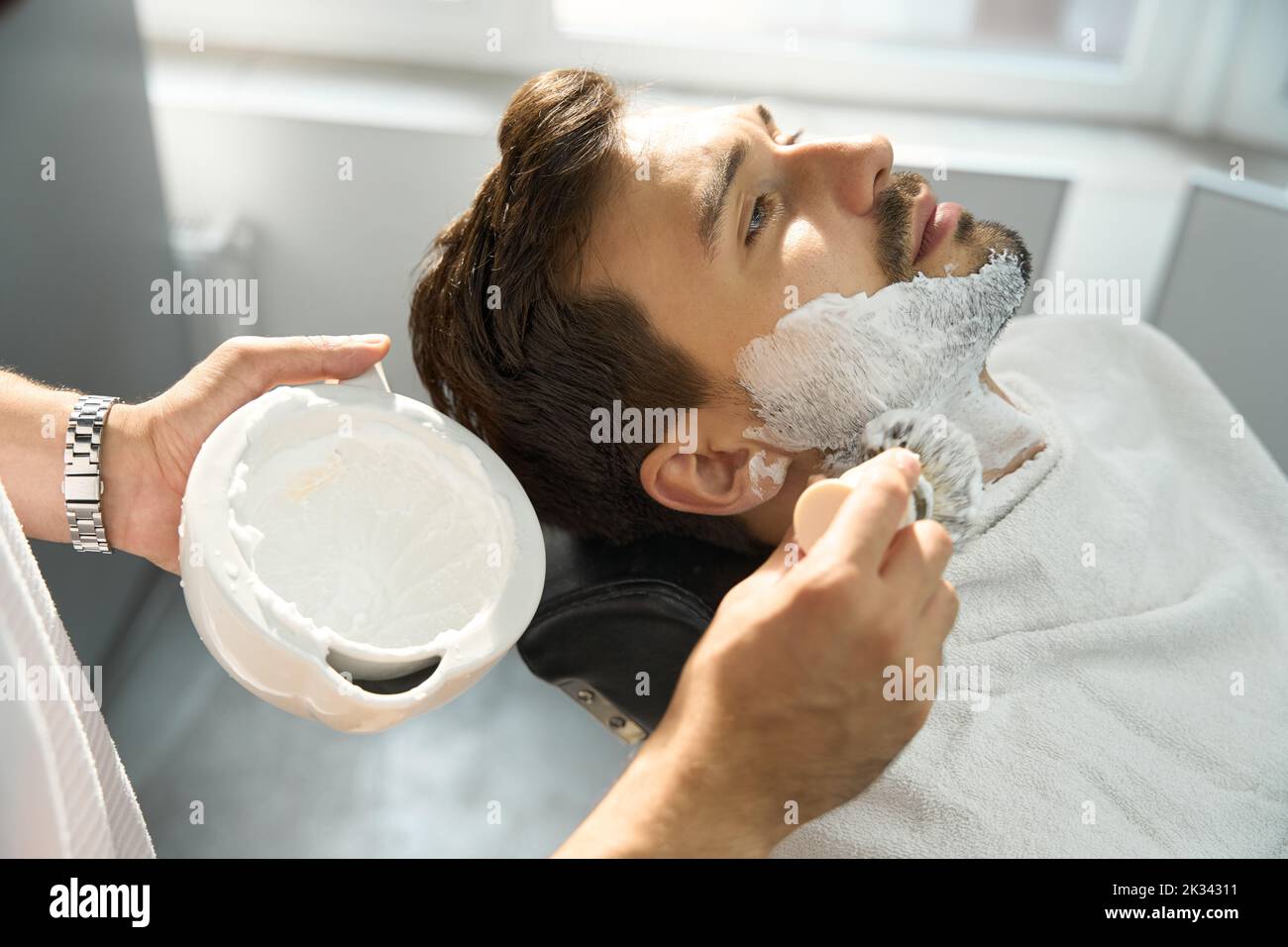 Un hair-groomer qualificato si prepara a dare al cliente una buona rasatura Foto Stock
