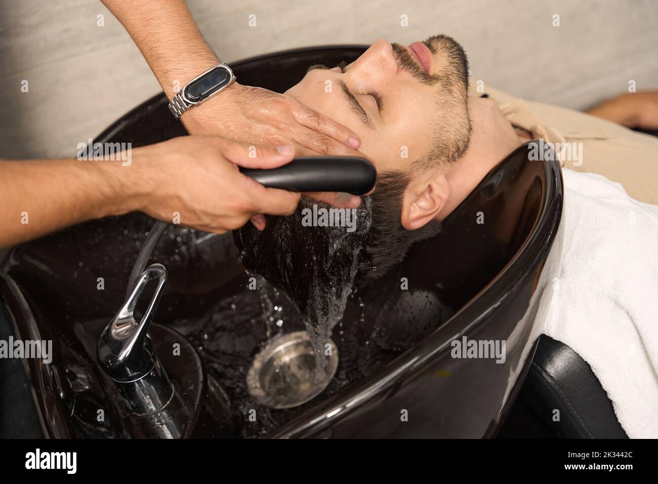 Bel ragazzo ottenere un lavaggio dei capelli al salone professionale Foto Stock