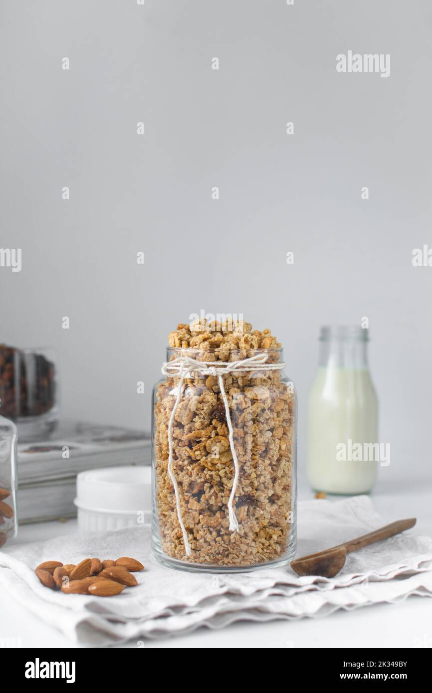 Granola in un grande vaso di vetro, avena e noci tostate in un vaso di vetro, miele e noci granola Foto Stock