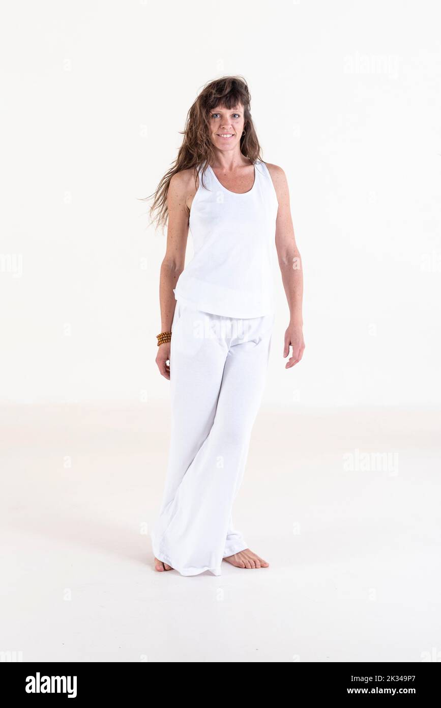 Ritratto di una donna vestita di abiti bianchi yoga su sfondo bianco guardando la fotocamera. Foto da studio Foto Stock