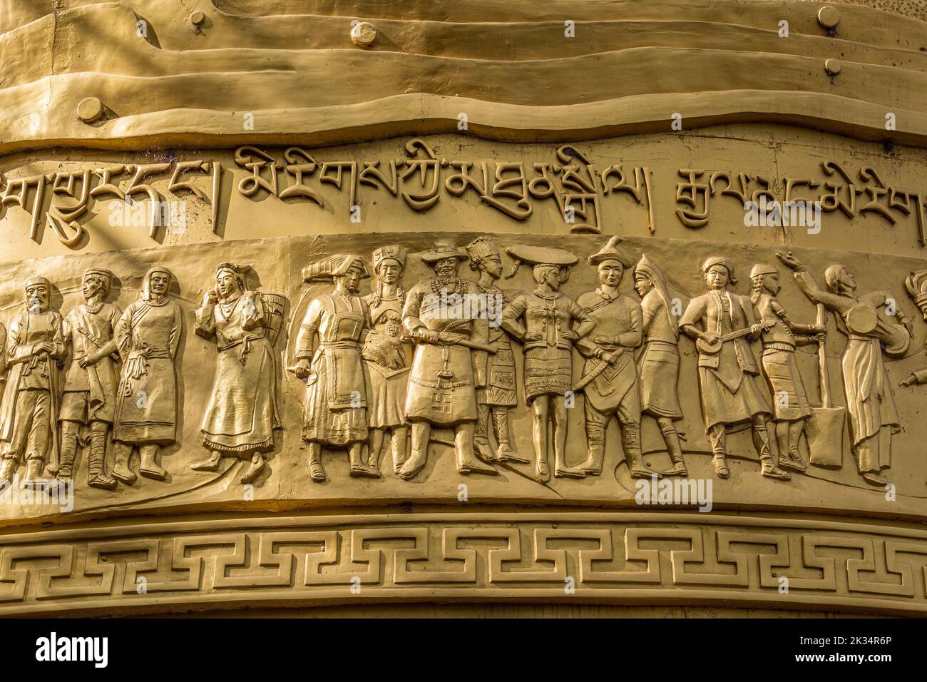 L'intricato lavoro di modellazione sulla gigantesca ruota di preghiera buddista, nel Parco di Gishan, Shangri-la, Yunnan, Tibet, Cina Foto Stock