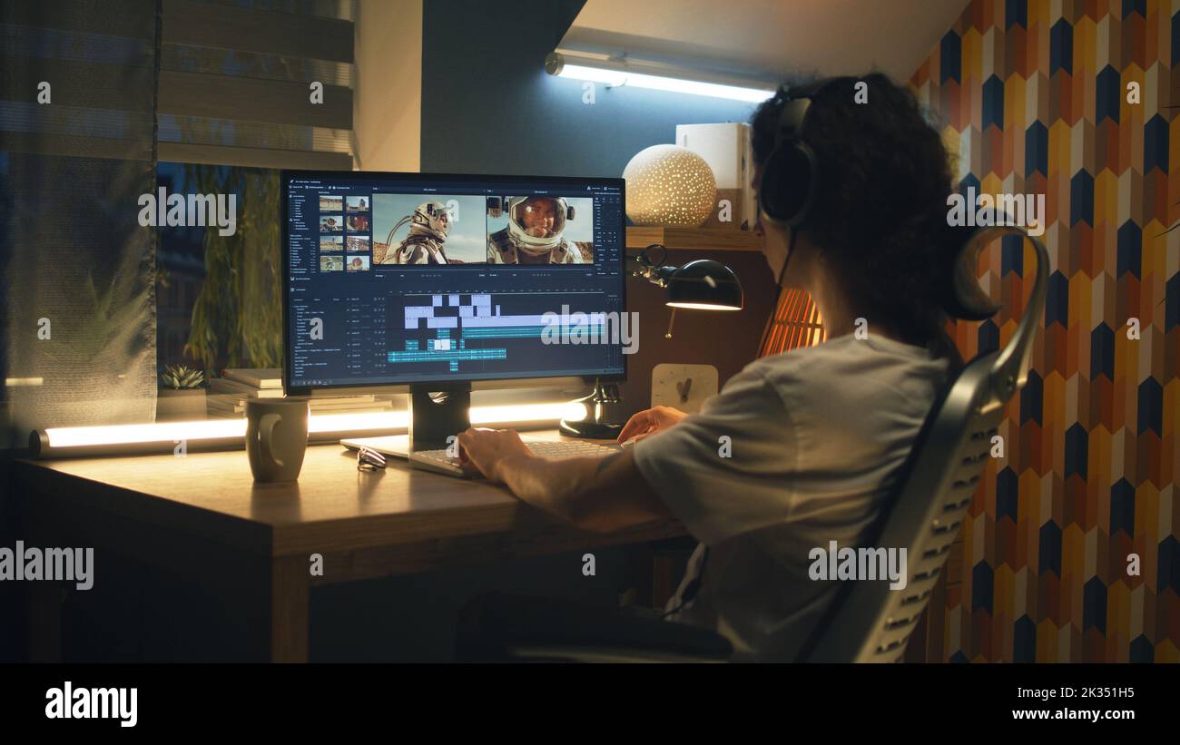 Guy in cuffie editing video con astronauti per lo spazio blog in programma professionale, mentre lavorando in remoto sul computer a casa Foto Stock