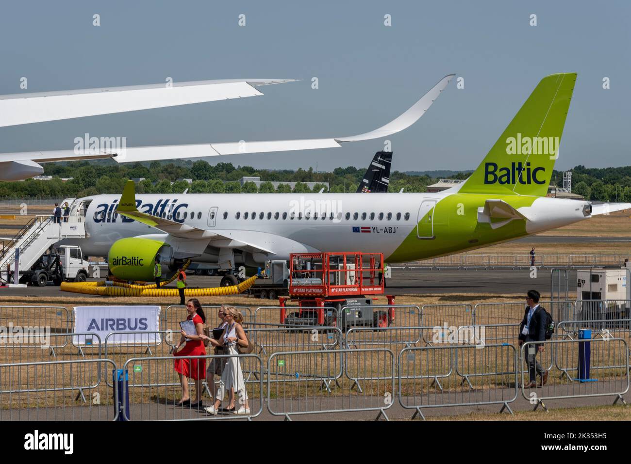 Fiera aerea internazionale di Farnborough 2022. Fiera aerospaziale, con Air Baltic Airbus A220 -300 Airliner jet plane in mostra da visitare. Visitatori femminili Foto Stock