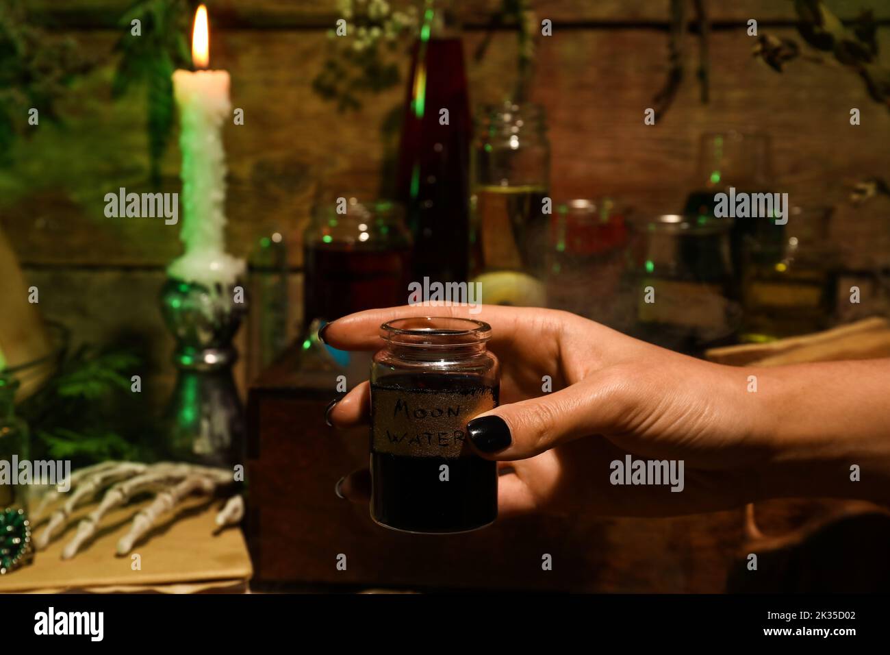 Vaso di sostegno strega con acqua di luna su sfondo di legno Foto Stock