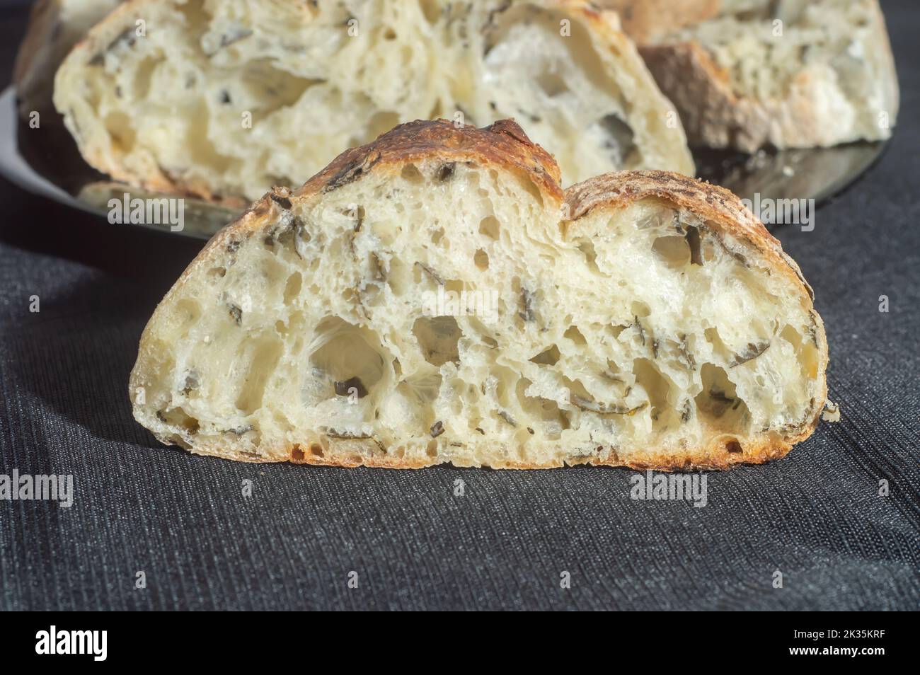 Pane fatto a mano con fermentazione naturale posto su un piatto nero. Foto Stock Pane fatto a mano con fermentazione naturale posto su un piatto nero. Foto Stock