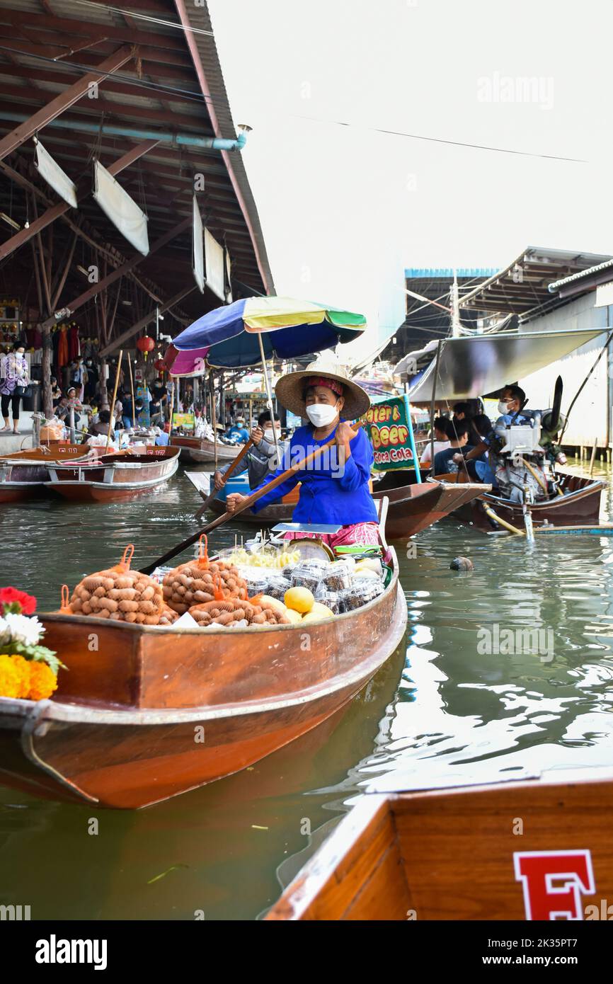 Ratchaburi, Thailandia 10 aprile 2022 - Damnoen Saduak mercato galleggiante venditori in Thailandia che vendono frutta, verdura e prodotti dalla loro barca. Foto Stock