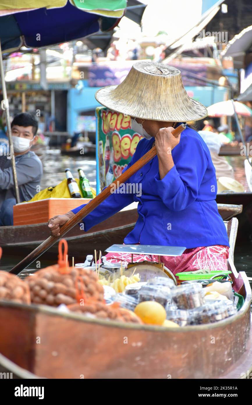 Ratchaburi, Thailandia 10 aprile 2022 - Damnoen Saduak mercato galleggiante venditori in Thailandia che vendono frutta, verdura e prodotti dalla loro barca. Foto Stock