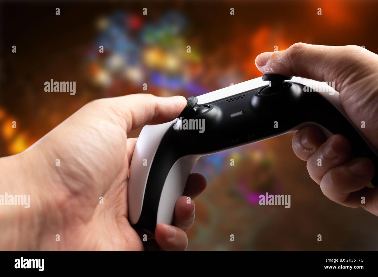 Sullo sfondo dello schermo di un personal computer, di una TV con un videogioco, il joystick GAM22ICB nelle mani di un giocatore. Passatempo divertente, hobby Foto Stock