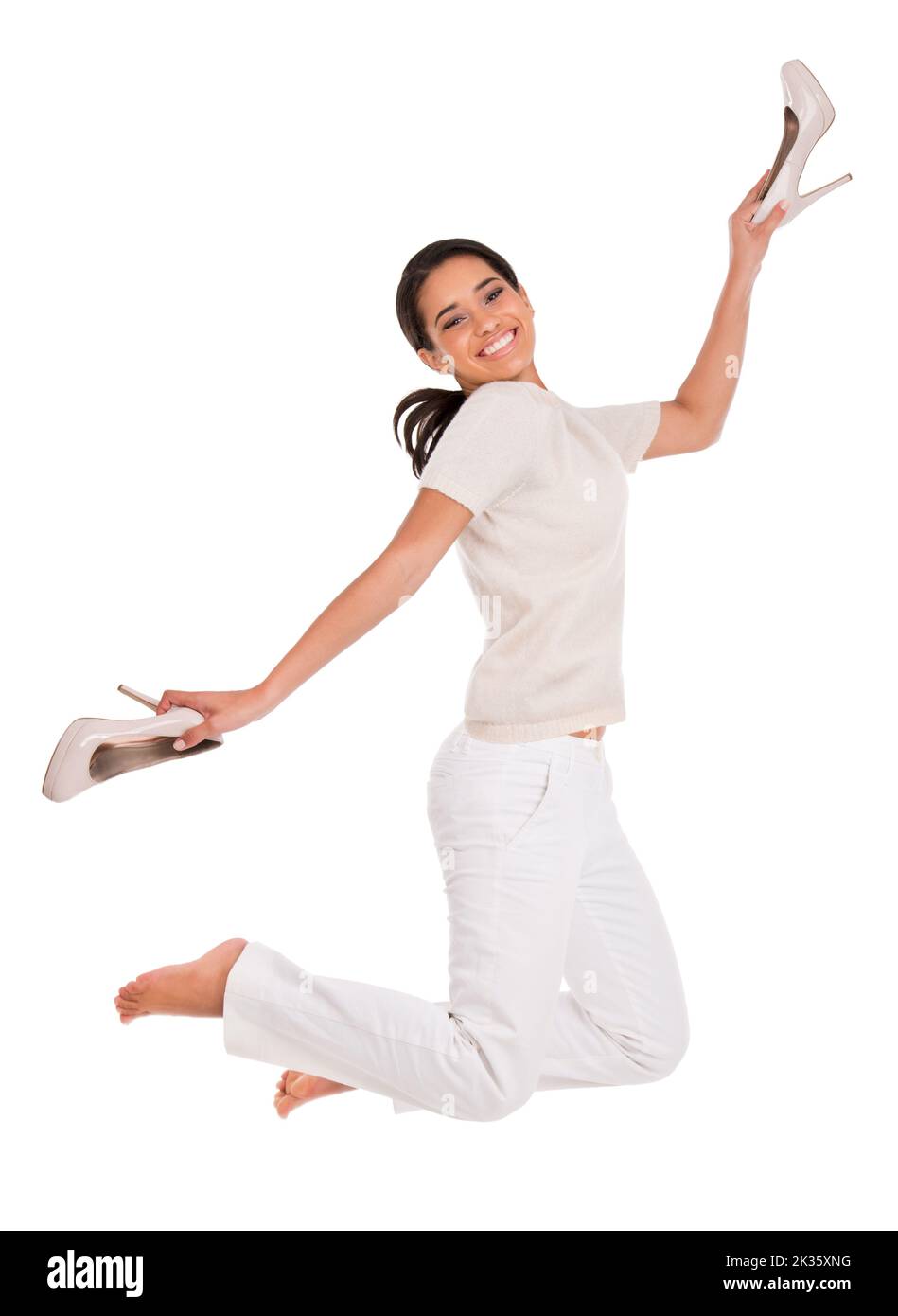 Ama le scarpe. Studio shot di una donna che tiene i tacchi alti e che salta in aria. Foto Stock