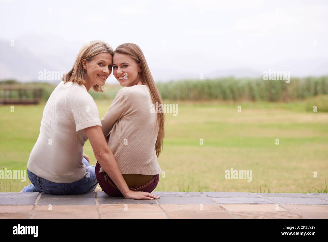 Trascorrere insieme del tempo di qualità. Una madre e una figlia seduti accanto fuori. Foto Stock