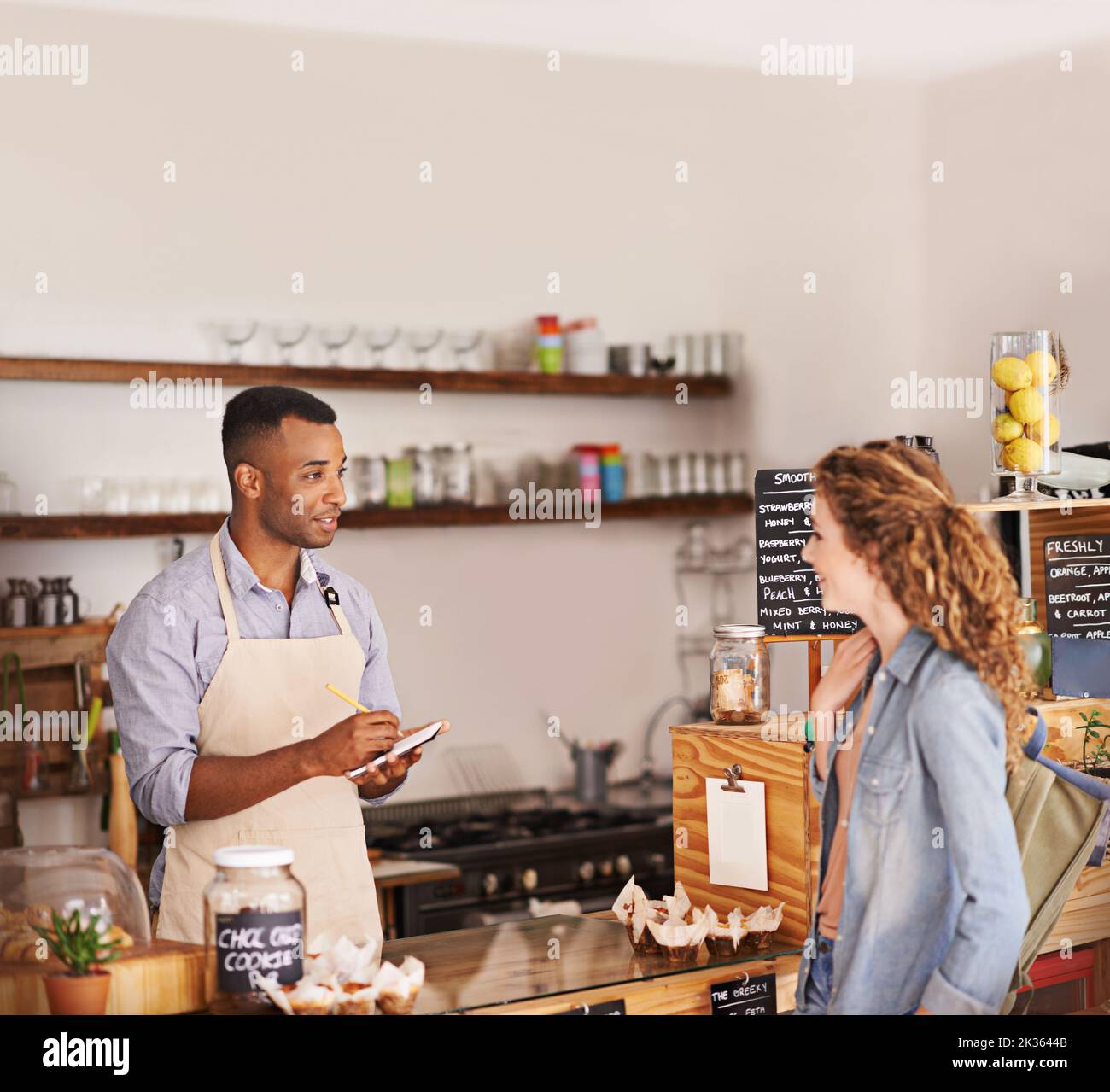 Volete che vada. Giovane barista che prende un ordine dei clienti in un bar. Foto Stock