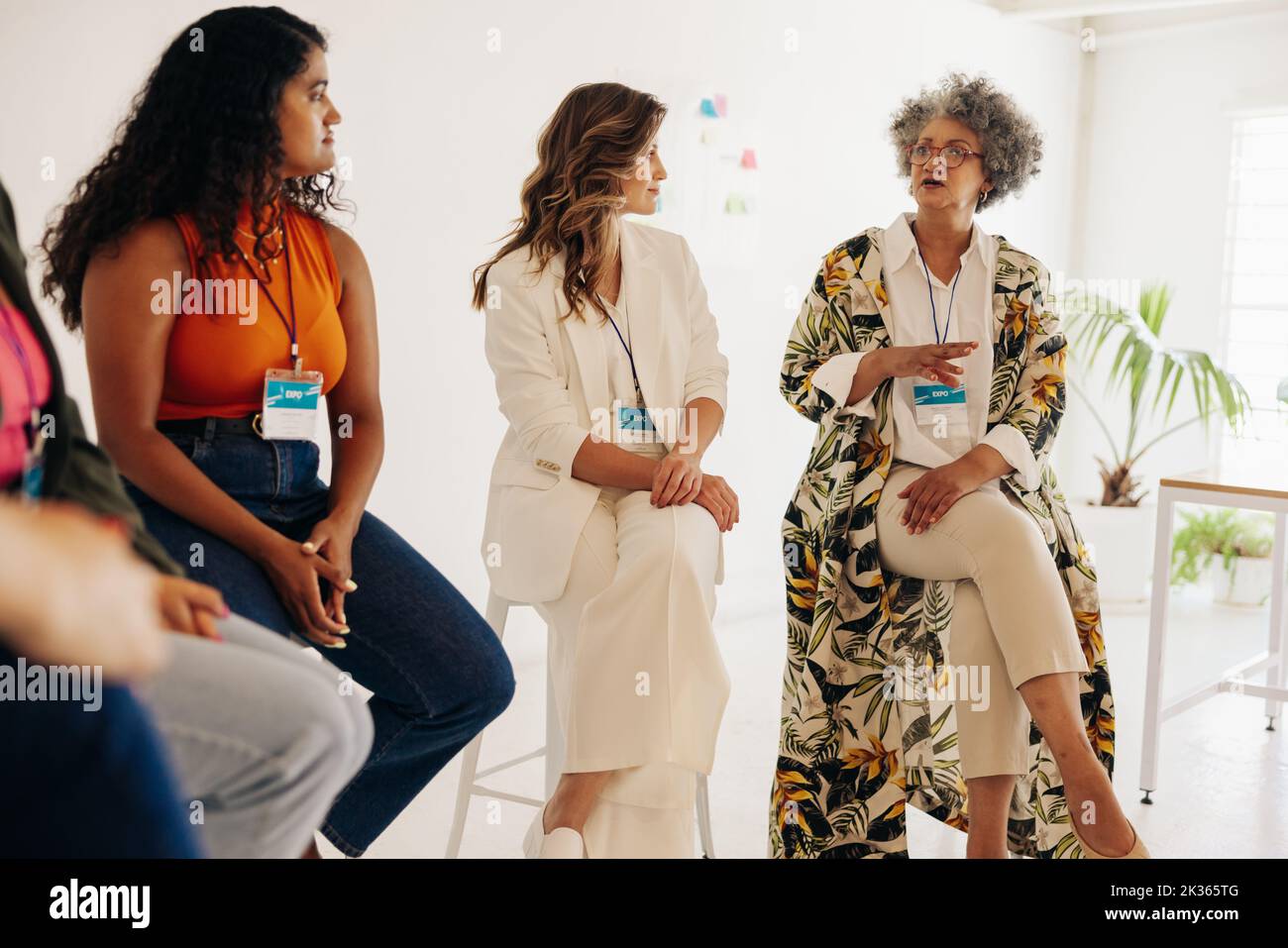 Gruppo di diverse donne d'affari che hanno una discussione durante una riunione di conferenza. Donne d'affari multiculturali che condividono idee mentre lavorano insieme in un Foto Stock
