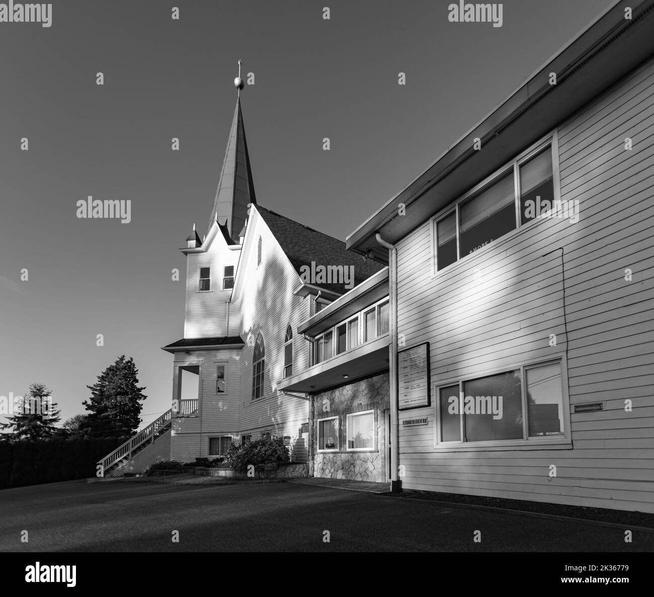 Facciata di una chiesa di legno bianco al tramonto in campagna. Chiesa luterana nella Columbia Britannica. Foto in bianco e nero Foto Stock