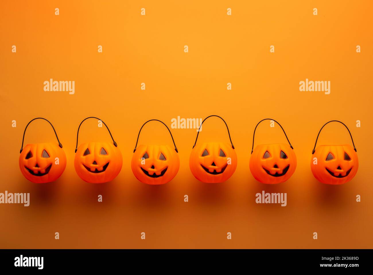 Decorazioni di Halloween con cestini di zucca su sfondo arancione Foto Stock