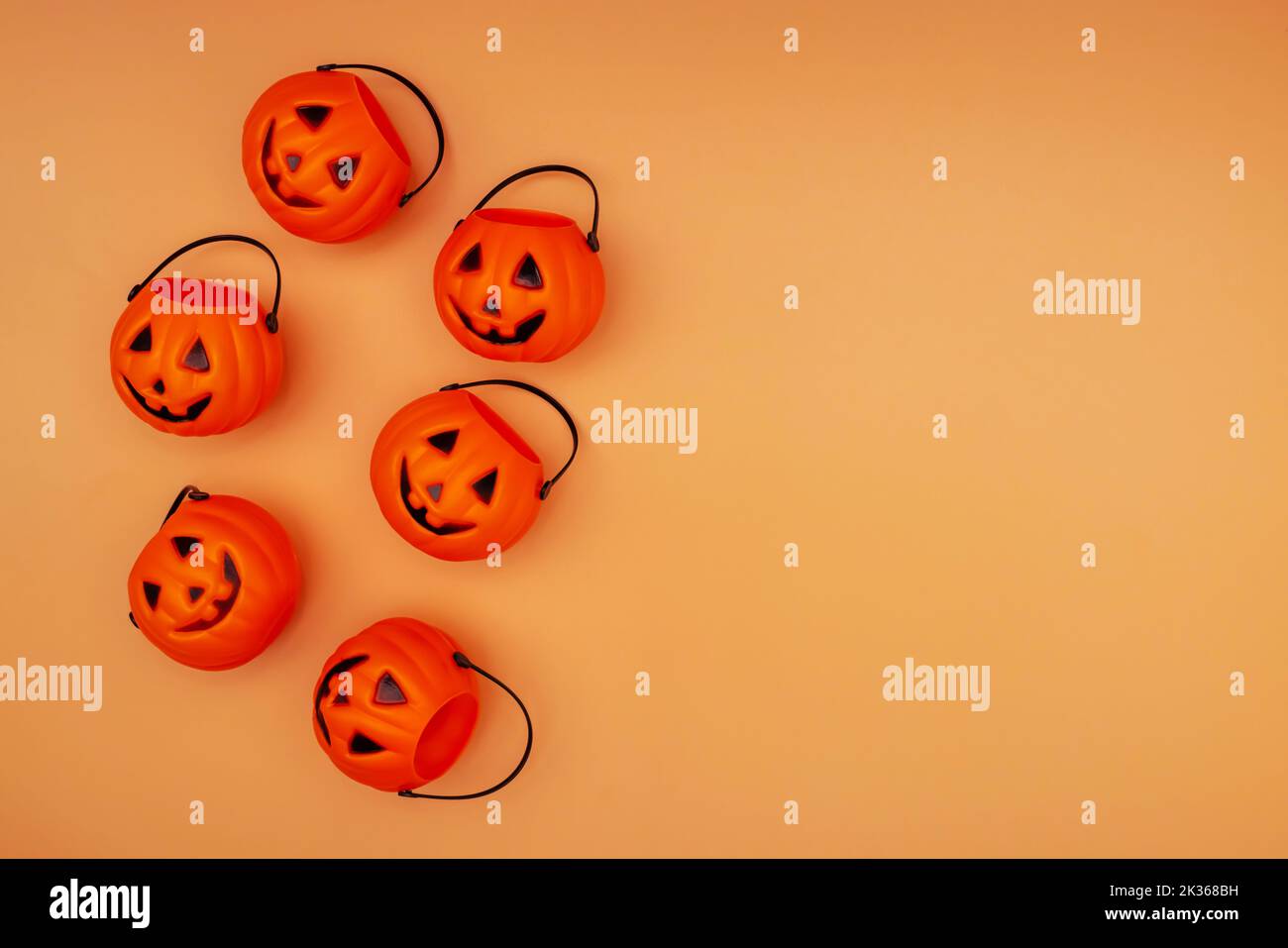 Decorazioni di Halloween con cestini di zucca su sfondo arancione Foto Stock