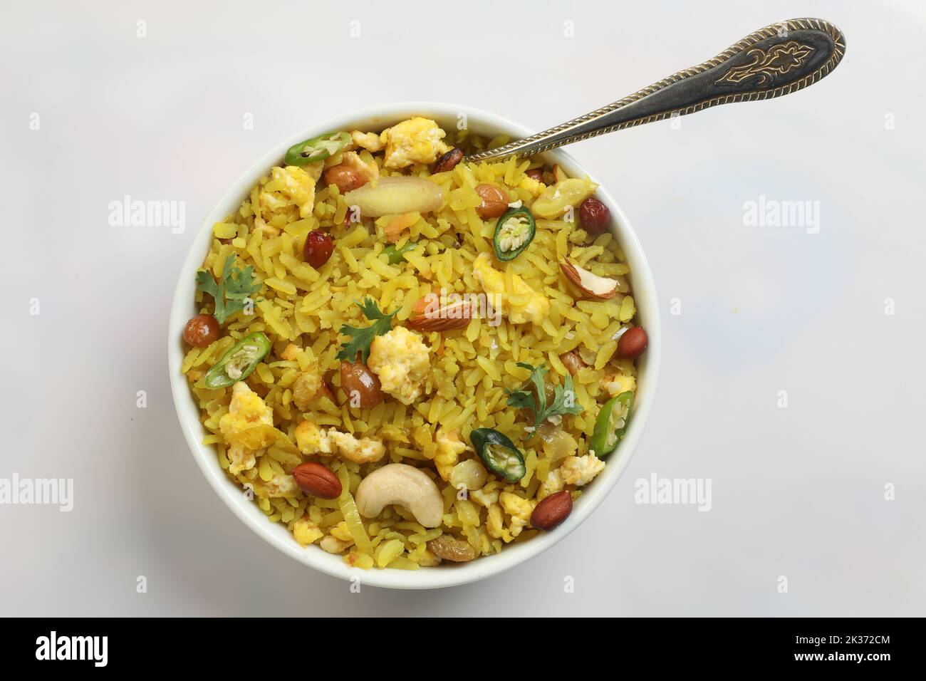 piatto indiano della colazione poha.Indian prima colazione POHA sormontato con arachidi, semi di melograno, freddo verde tagliato, cipolla, lime, foglie di coriandolo e curry Foto Stock