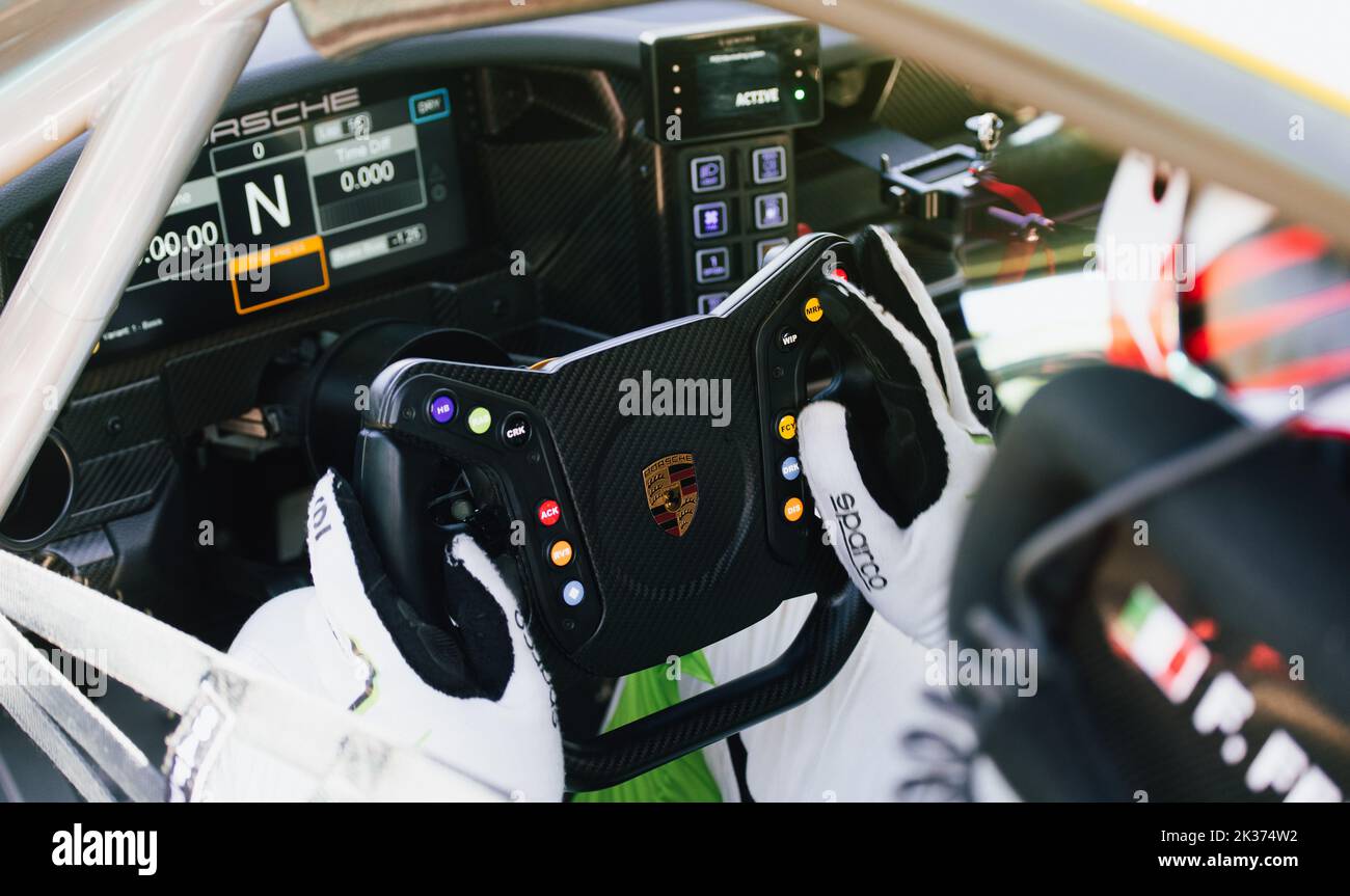 Primo piano del pilota di auto da corsa cockpit, mani sul volante con logo Porsche. Italia, 17-18 2022 settembre, weekend di corse Foto Stock