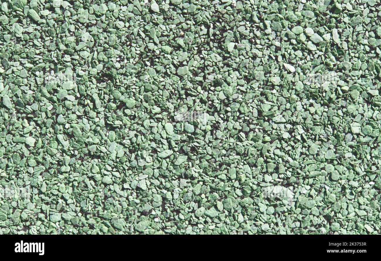 Gomma morbida pavimento granulare a grana grossa primo piano superficie, materiale verde chiaro sfondo texture Foto Stock