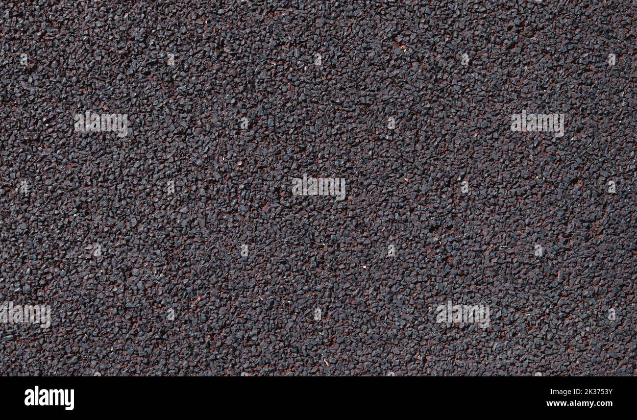 Pavimenti in gomma morbida, primo piano della superficie granulare, sfondo con struttura in materiale rosso scuro Foto Stock