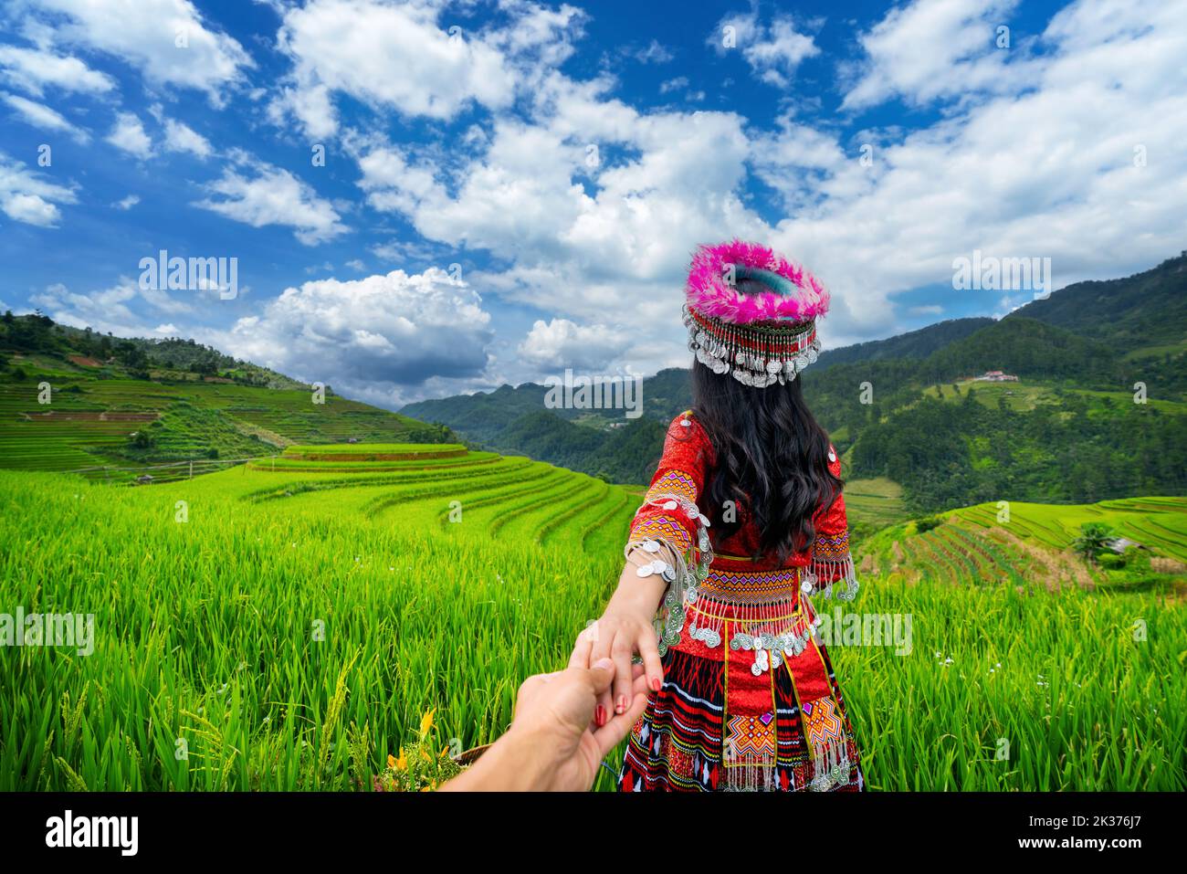 La minoranza etnica Hmong tiene la mano dell'uomo e lo conduce alle terrazze di riso a Mu Cang Chai, Yen Bai, Vietnam. Foto Stock