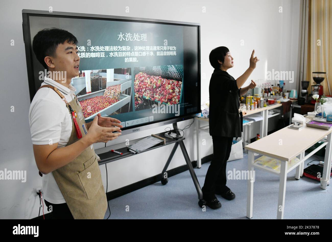 (220925) -- XI'AN, 25 settembre 2022 (Xinhua) -- l'istruttore di formazione Sun Yu (L) e l'insegnante di linguaggio dei segni Qu Wenmin sono visti durante un corso di formazione per baristi alla Shaanxi Urban Economy School di Xi'an, capitale della provincia Shaanxi del nord-ovest della Cina, 22 settembre 2022. La Giornata Internazionale dei sordi cade la quarta domenica di settembre. Dal 2019, la Shaanxi Urban Economy School offre formazione gratuita ai baristi per i non udenti. Durante il programma di formazione, i partecipanti possono apprendere le capacità di preparazione del caffè e le conoscenze relative al funzionamento del caffè, che potrebbero aiutarli a spianare la strada Foto Stock