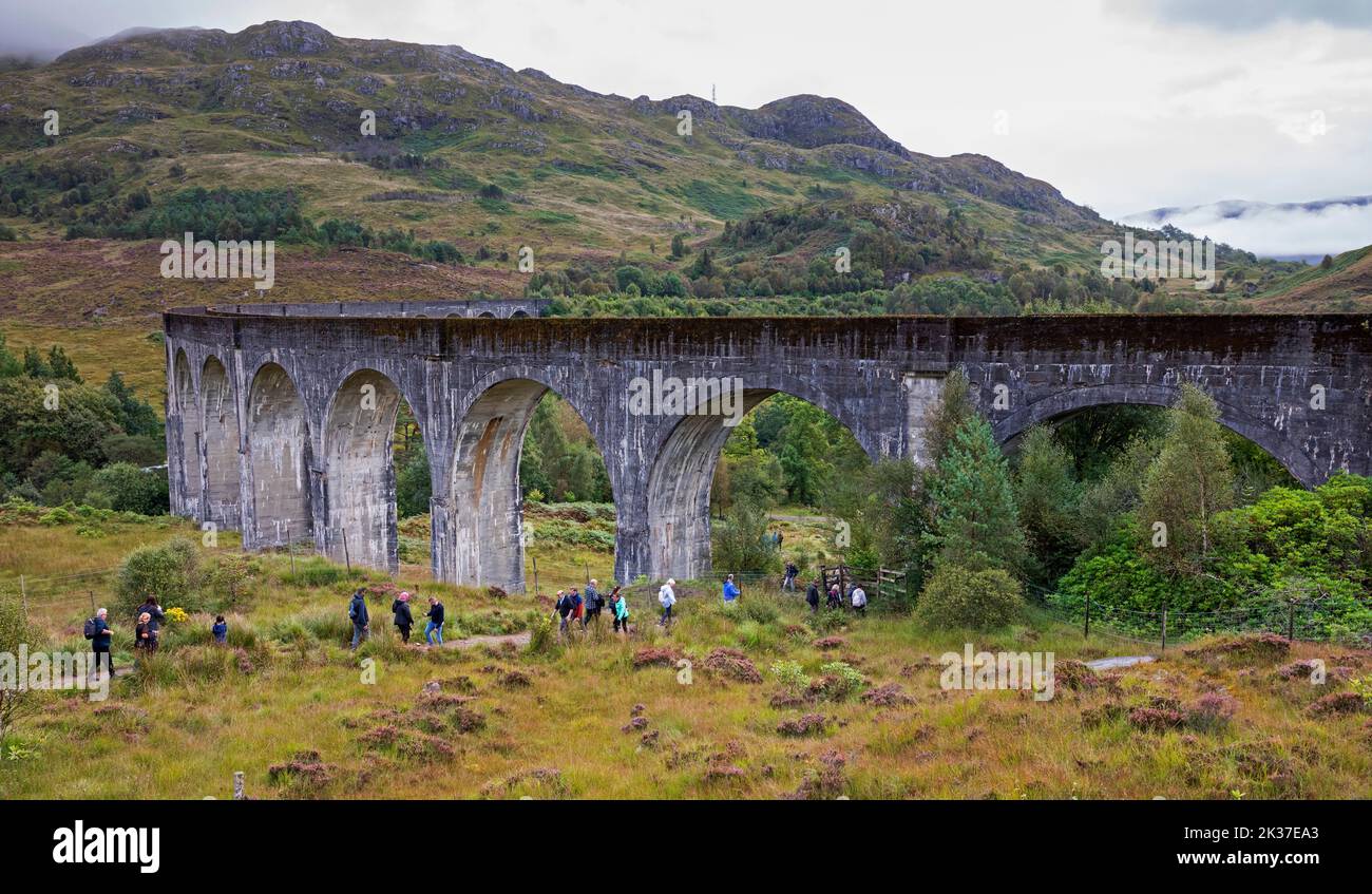 I turisti lasciano la collina sopra il Viadotto di Glenifinnan, Lochaber, Highlands scozzesi, Scozia, Regno Unito Foto Stock