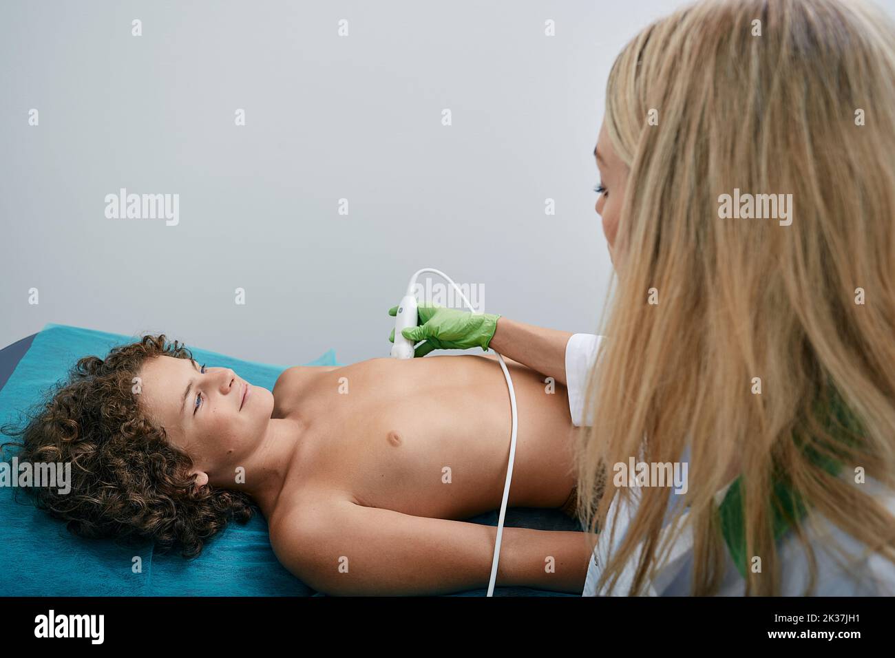 Paziente ragazzo che si sta monitorando la salute del cuore utilizzando l'elettrocardiogramma con cardiologo donna. Analisi cardiogrammo per bambini Foto Stock