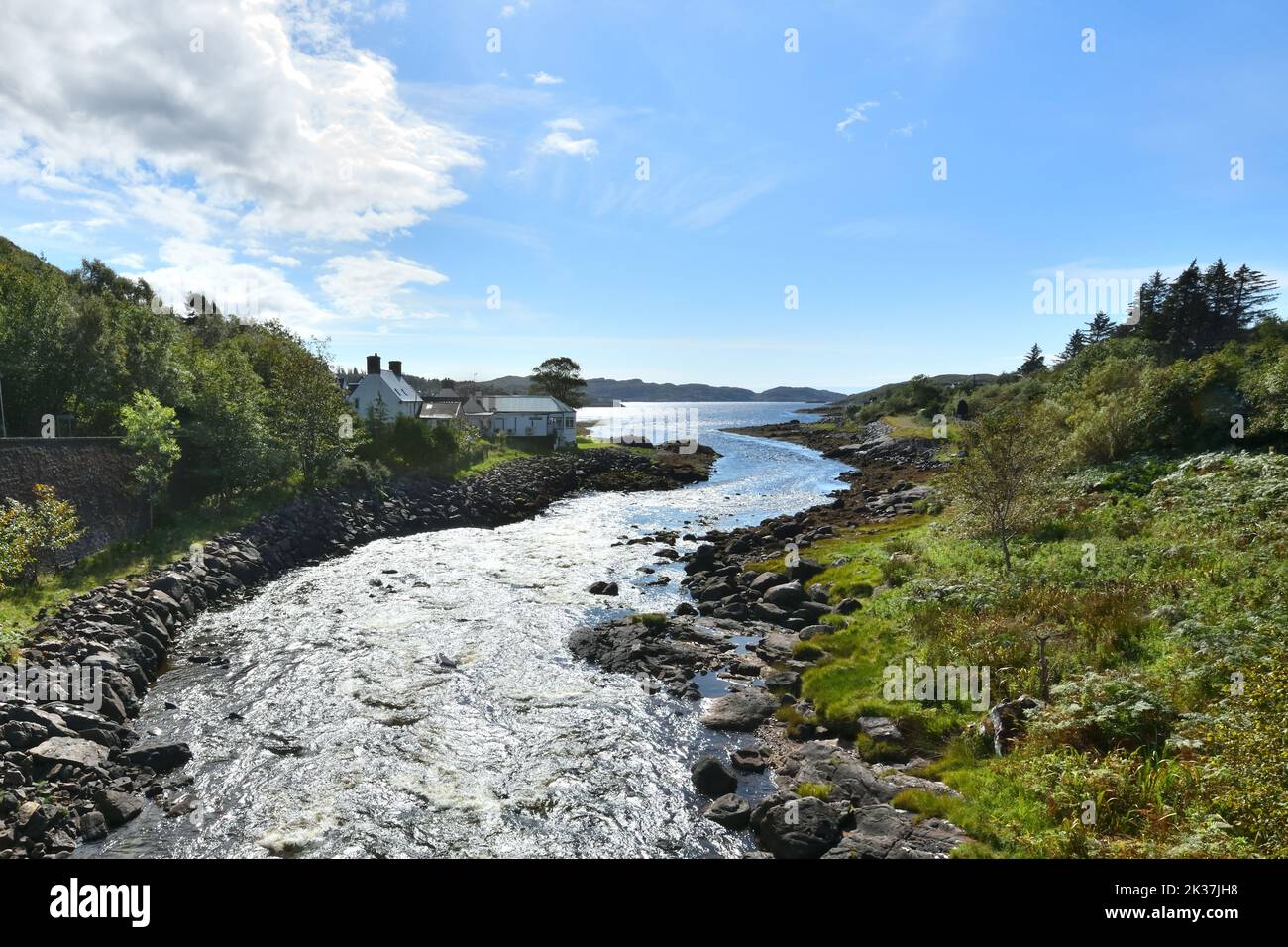 Il fiume Inver che corre nel lago di mare Loch Inver, sulla costa occidentale nel distretto di Assynt di Sutherland, Highland, Scozia. Foto Stock