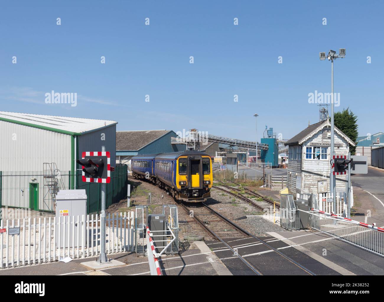 Treno diesel classe 156 della East Midlands che passa per la scatola di segnalazione meccanica all'incrocio di Barrow Road, New Holland sulla Barton line, Regno Unito Foto Stock