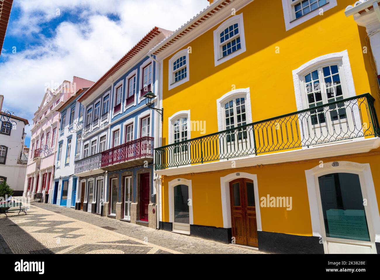 Le colorate facciate color pastello degli edifici in stile neoclassico lungo la passerella pedonale della Rua da Esperanca terminano al rosa Teatro Angrense, un teatro d'arte dello spettacolo ad Angra do Heroismo, Isola di Terceira, Azzorre, Portogallo. Foto Stock