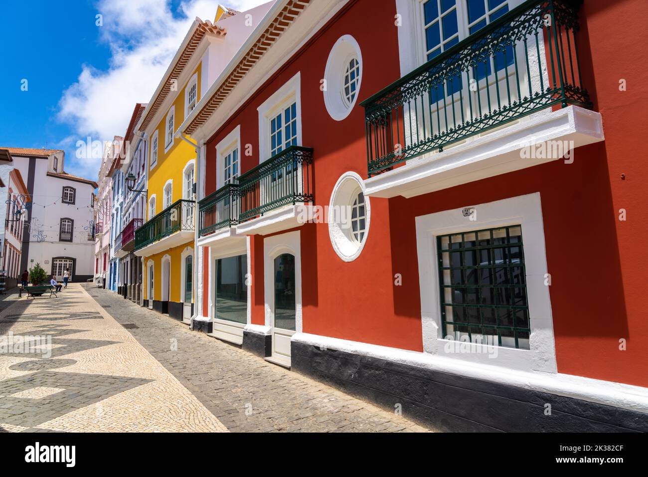 Le colorate facciate color pastello degli edifici in stile neoclassico lungo la passerella pedonale della Rua da Esperanca terminano al rosa Teatro Angrense, un teatro d'arte dello spettacolo ad Angra do Heroismo, Isola di Terceira, Azzorre, Portogallo. Foto Stock