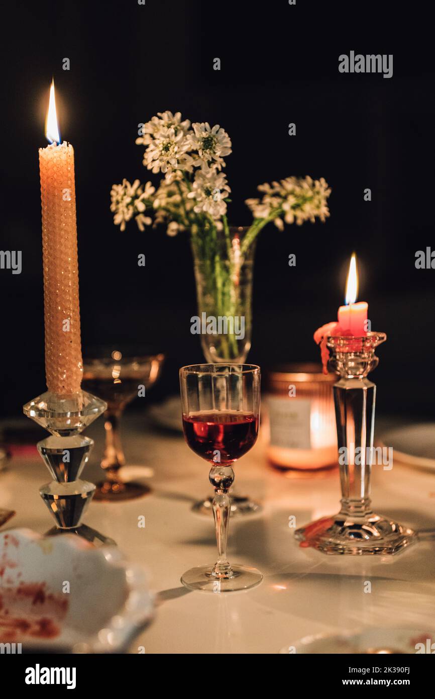 tavolo da sera con candele, cocktail, vino, fiori Foto Stock