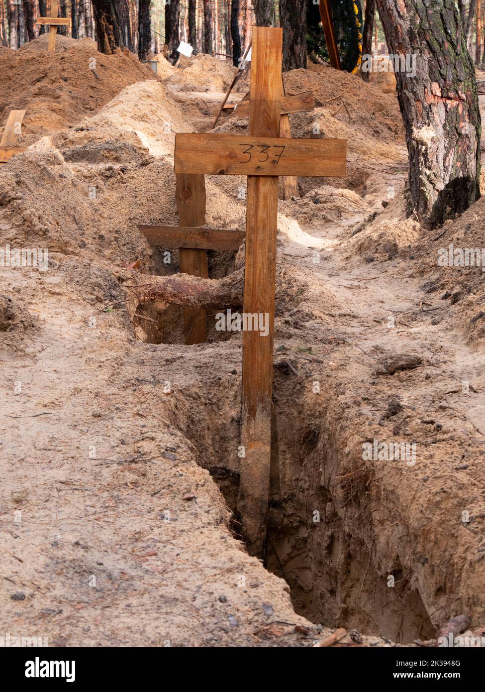 Le tombe sono vuote come parte di un'indagine sui crimini di guerra a Izium, Ucraina. Oltre 400 corpi sono stati recuperati dalle tombe di massa a Izium dopo la liberazione da un'occupazione di sei mesi. Foto Stock