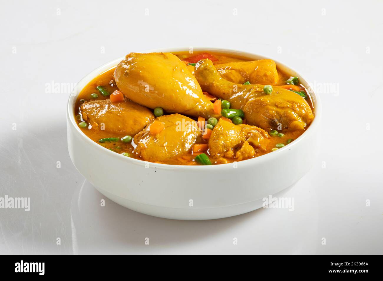 Curry di pollo in ciotola bianca su fondo bianco Foto Stock