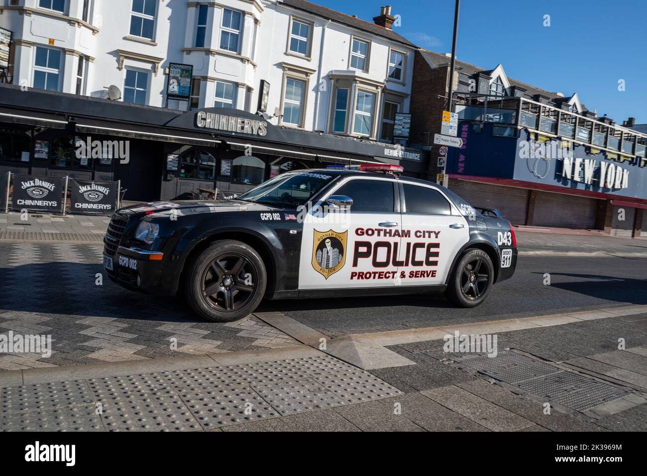 Auto della polizia di Gotham City segnata Chrysler 300 che guida sulla Marine Parade a Southend on Sea, Essex, Regno Unito. Proteggi e servi lo slogan. Passando dalla galleria di New York Foto Stock