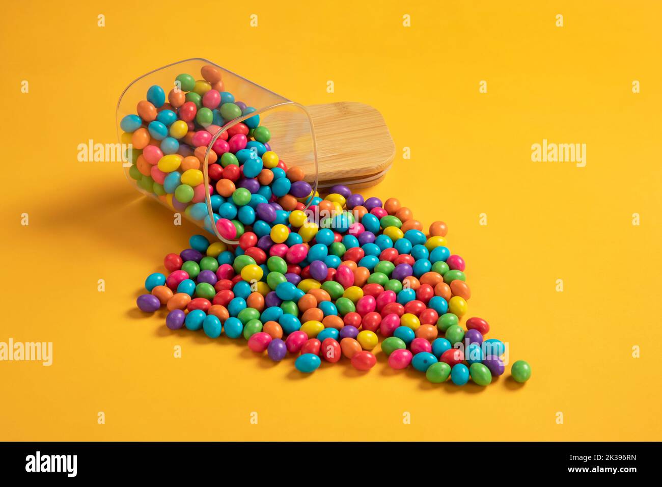 Caramelle al cioccolato colorate assortite, caramelle al cioccolato rivestite di zucchero. Cioccolato Candy Gems su sfondo colorato. Foto Stock