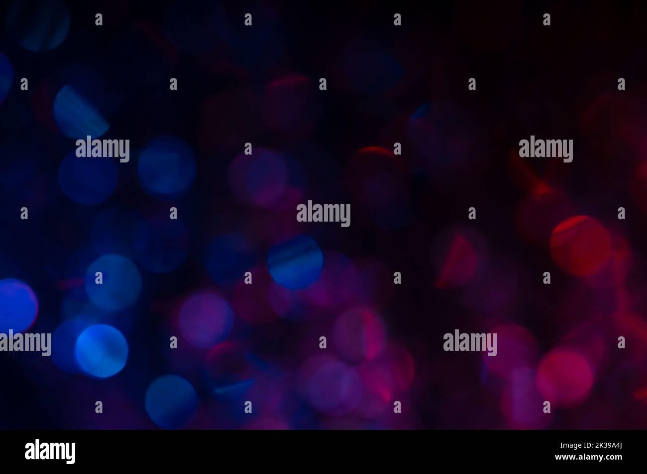 Il bokeh rosso e blu si affievolisce verso il nero in alto Foto Stock